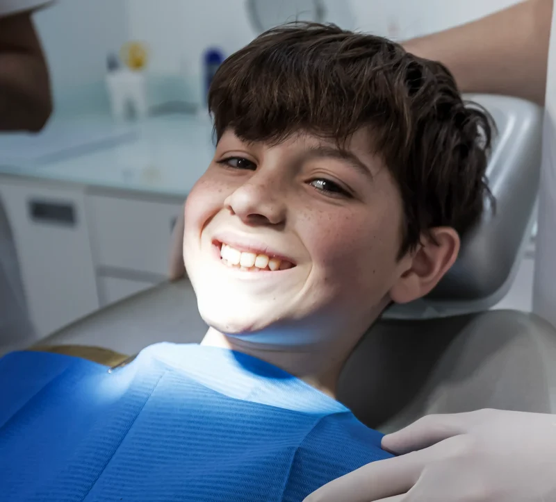 Niño tranquilo y sonriente en silla dental en Germantown Pediatric Dental Center — solución para ansiedad dental infantil