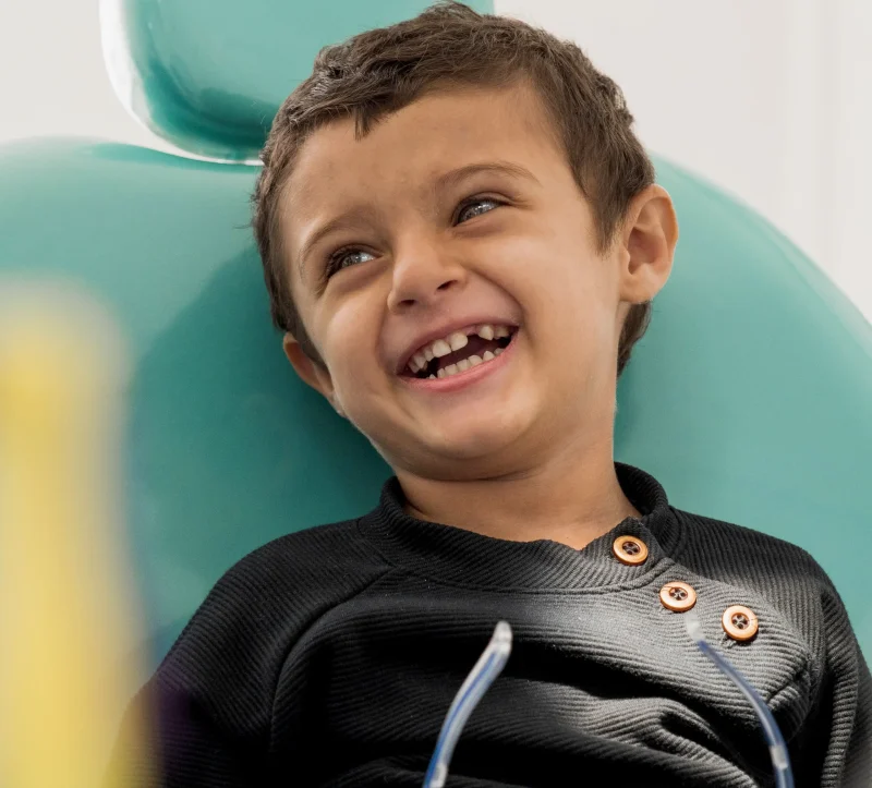 Niño feliz y relajado en silla dental en Germantown Pediatric Dental Center — sedación dental para niños